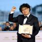 Bong Joon-Ho shows off his Palme d'Or prize in Cannes