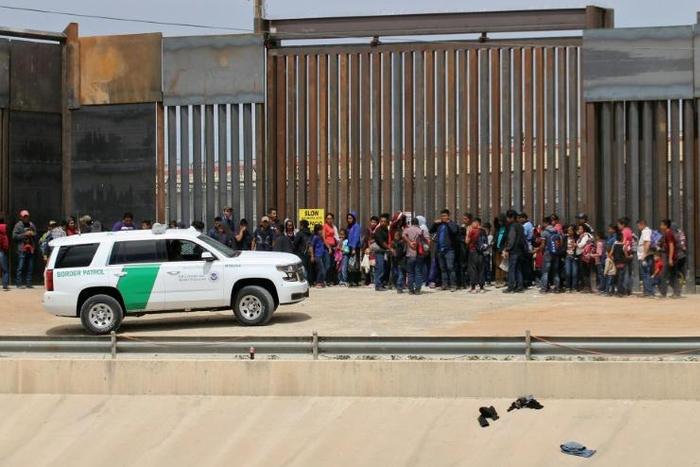 Central American migrants are detained by US Customs and Border Patrol agents at the border wall in Ciudad Juarez, Mexico, on May 7, 2019