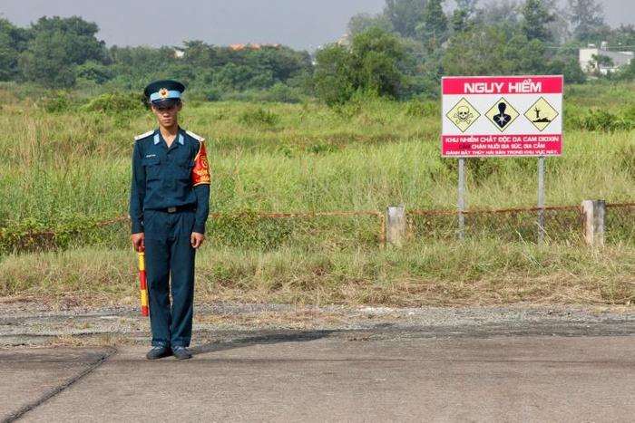 A Vietnamese soldier stands next to a sign warning of toxic hazard at Bien Hoa air base, on the outskirts of Ho Chi Minh City