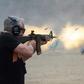 A man fires a machine gun on the main firing line during the Knob Creek Machine Gun Shoot