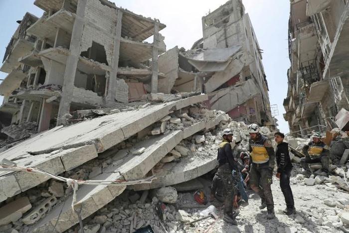 Members of the "White Helmets" rescue group search the rubble of a collapsed building after a previous strike in Idlib's Jisr al-Shughur on Wednesday