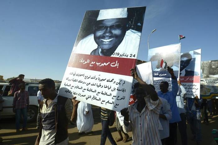 Sudanese protesters carry pictures of fellow demonstrators killed in clashes with security forces