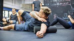 Man rolling on foam roller at health club