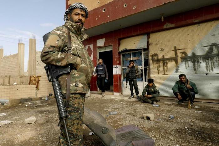 Members of the Syrian Democratic Forces rest during an operation to expel Islamic State group jihadists from their last bastion in eastern Syria