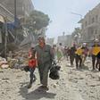 Members of the Syrian Civil Defence (known as the White Helmets) carry a wounded man on a stretcher after a reported air strike Maaret al-Numan in the jihadist-held Idlib province as others flee the scene