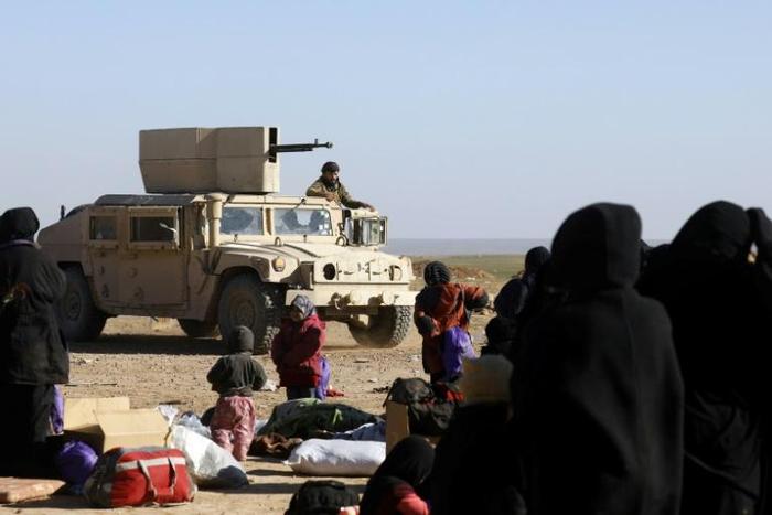 Civilians fleeing territory controlled by the Islamic State group in eastern Syria wait to be screened by US-backed forces on February 3, 2019