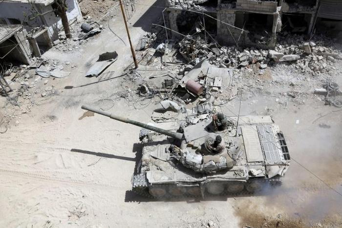 Syrian soldiers advance in an area on the eastern outskirts of Douma on April 8, 2018