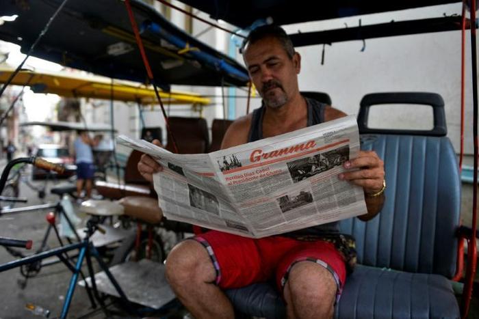 A man reads a slimmed-down edition of Cuban daily Granma in Havana, part of the country's first newspaper cut since 1990