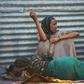 An elderly woman weakened by hunger lies on the ground as her daughter watches over her at a camp for the internally displaced on the outskirts of Baidoa town, the capital of Bay region of south-western Somalia