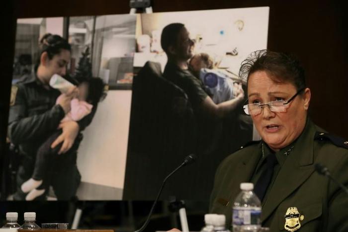 Carla Provost, chief of the US Border Patrol, speaks during a Senate hearing in front of pictures of border patrol agents assisting children