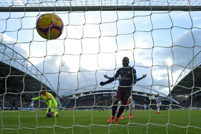 French striker Alexandre Lacazette scored as Arsenal beat bottom side Huddersfield Town to maintain their hopes of securing a Champions League spot