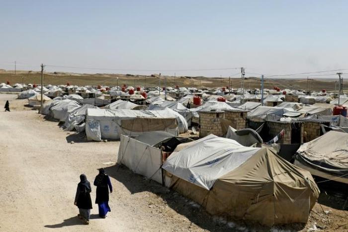 Women stroll in a camp for people who were affilated with the Islamic State group in the northern Syrian village of Malikiya in September 2018