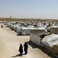Women stroll in a camp for people who were affilated with the Islamic State group in the northern Syrian village of Malikiya in September 2018
