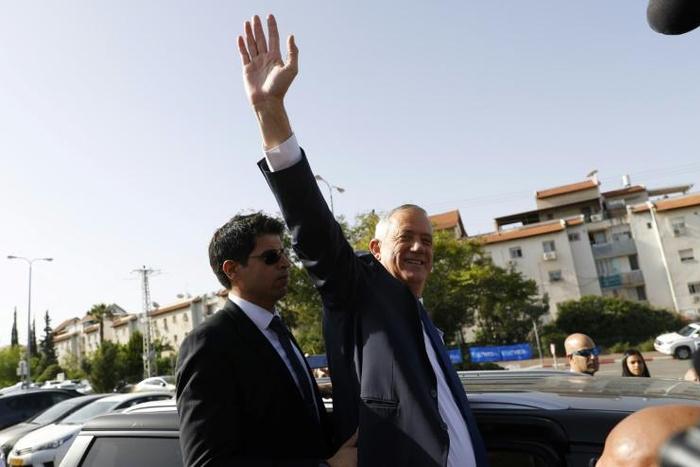 Retired Israeli general Benny Gantz, one of the leaders of the Blue and White (Kahol Lavan) political alliance, waves after casting his vote during Israel's elections