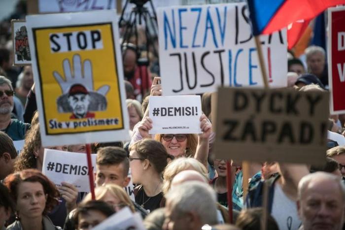 A demonstrator holds a placard reading "#Demisi" (C) during a protest against the government led by Andrej Babis in Wenceslas Square in Prague, Czech Republic on May 21, 2019