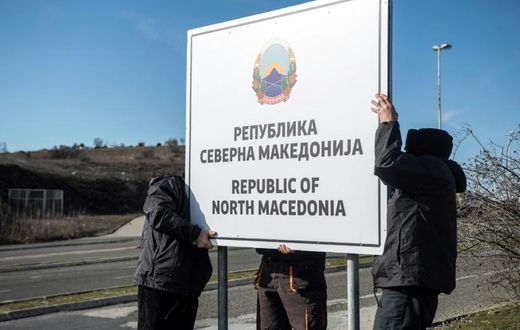Workers set up a sign reading 'Republic of North Macedonia' at the Macedonia-Greece border near Gevgelija on February 13, 2019