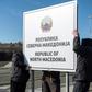 Workers set up a sign reading 'Republic of North Macedonia' at the Macedonia-Greece border near Gevgelija on February 13, 2019