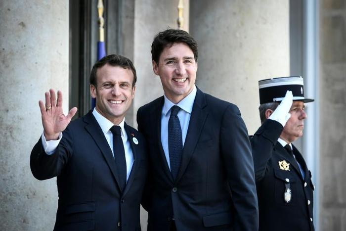 French President Emmanuel Macron (l) welcomes Canadian Prime Minister Justin Trudeau upon his arrival at the Elysee Palace in Paris