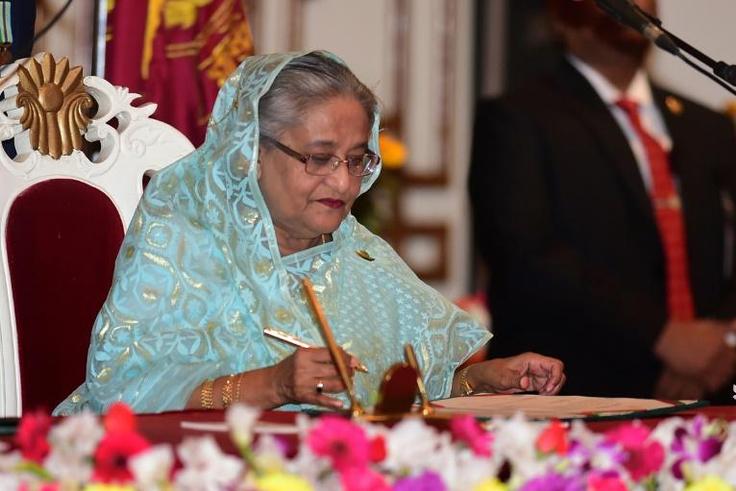 Sheikh Hasina signs documents after being sworn in for her fourth spell as Bangladesh's prime minister