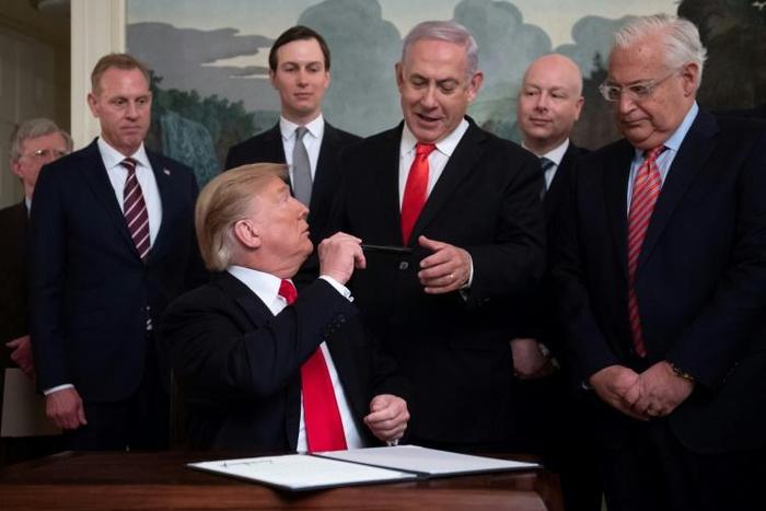 US President Donald Trump hands his pen to Israeli Prime Minister Benjamin Netanyahu after signing a proclamation recognizing the Golan as Israeli territory despite UN resolutions that state the strategic plateau is Syrian