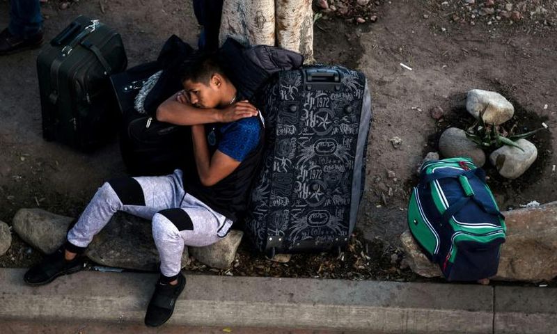 An asylum seeker rests outside El Chaparral port of entry while he waits for his turn to present himself to US border authorities to request asylum, in Tijuana, Mexico, on April 9, 2019
