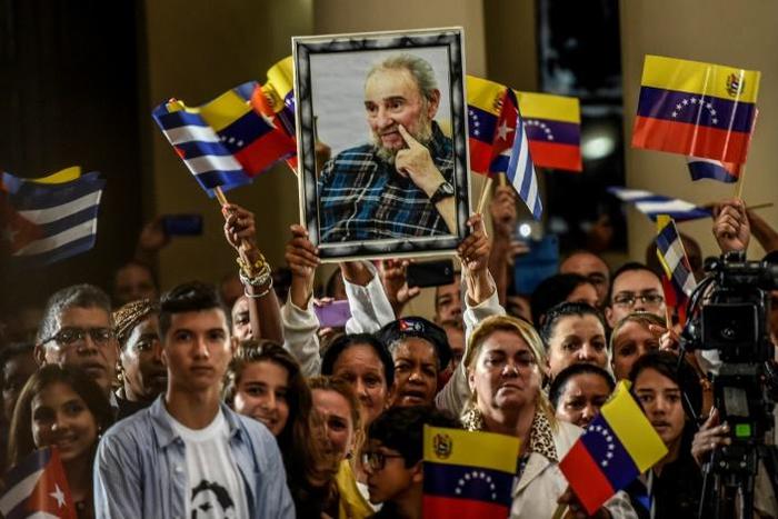 Supporters of Venezuelan President Nicolas Maduro, seen in 2016, brandish a picture of late Cuban leader Fidel Castro the day after his death