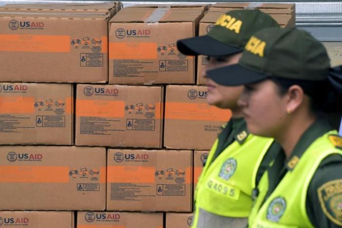 Colombian policewomen walk past boxes with US humanitarian aid goods in Cucuta, Colombia, on the border with Tachira, Venezuela, on February 8, 2019