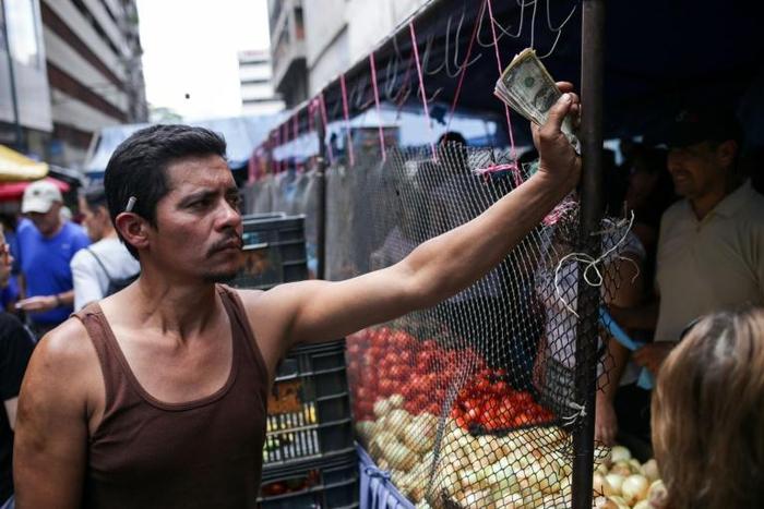 In some Caracas shops and markets, vendors are only accepting cash -- dollars or bolivars -- making it harder for some people to buy basic foods