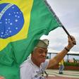 A supporter of President Jair Bolsonaro waves a Brazilian flag during a demonstration in support of the ultraconservative government as it faces growing opposition