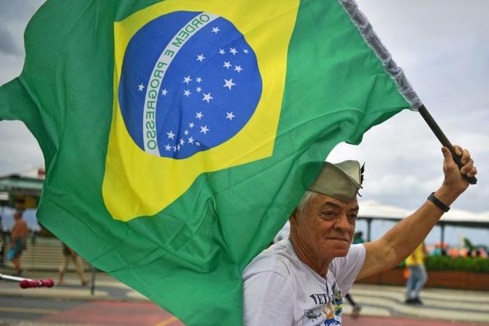A supporter of President Jair Bolsonaro waves a Brazilian flag during a demonstration in support of the ultraconservative government as it faces growing opposition