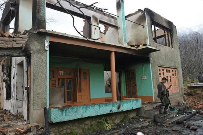 A Kashmiri villager stands next to the remains of a house destroyed during a deadly gun battle between militants and Indian government forces in Tral on Sunday