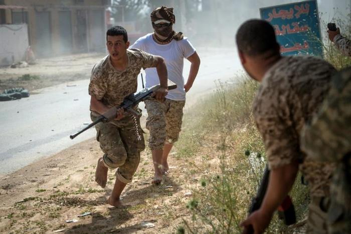Fighters loyal to Libya's internationally recognised unity government run for cover during recent clashes with the self-styled Libyan National Army