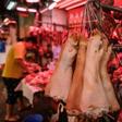 Pig trotters hang from hooks at a meat market in Hong Kong, where the price of pork has soared since the outbreak of African swine fever