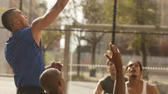 Men playing basketball on court