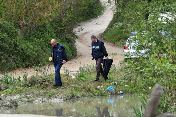 Murataj, armed with an automatic rifle and a grenade, was killed in a shootout with the police on a nearby road. Here, police are shown combing the area for clues