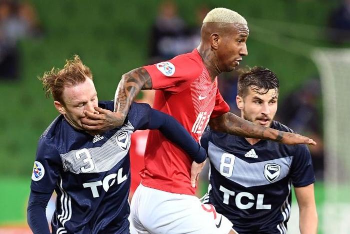Guangzhou's Anderson Talisca fends off Melbourne Victory's Corey Brown (left) and Terry Antonis
