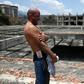 Venezuelan Erick Hurtado, with Bolivar bills equivalent to less than a US dollar tucked into his waistband, stands on the roof of Jehovah Gire, a half-done building in the Petare neighborhood of Caracas that is now home to dozens of squatters