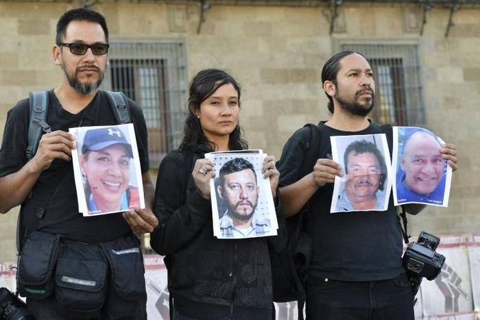 Journalists hold up photos of slain colleagues at a rally in Mexico City in June 2018