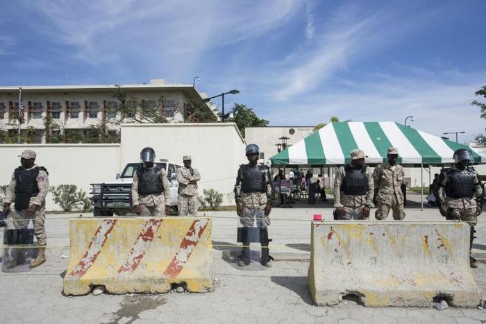 Police stand guard as Haitians gather in front of the US Embassy in Port-au-Prince January 18, 2018