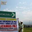 Men protest with a sign calling for peace near the Tienditas Bridge which links Venezuela and Colombia, after Venezuelan military forces blocked it