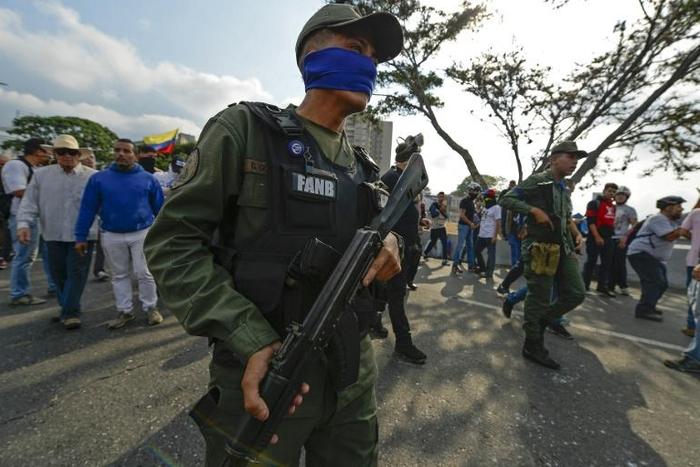 Soldiers identify themselves as supporters of Venezuelan opposition leader Juan Guaido with blue sashes