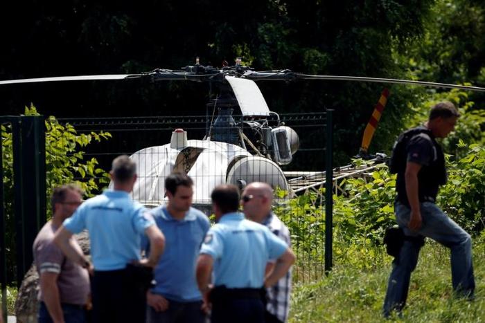 A picture taken on July 1, 2018, north of Paris shows police near a French helicopter Alouette II abandoned by French armed robber Redoine Faid after his escape from prison in Reau.