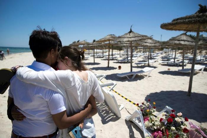 In a photo taken on June 27, 2015, a couple react at the site of the jihadist shooting rampage on the beach in front of the Riu Imperial Marhaba Hotel in Sousse, south of the Tunisian capital, that killed 38 people
