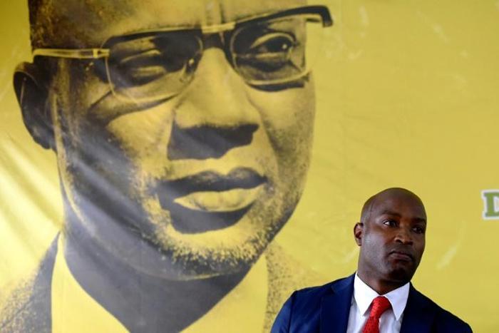 The founder of Guinea-Bissau's PAIGC party, Amilcar Cabral, looks down as spokesman Joao Bernardo Vieira speaks to the press