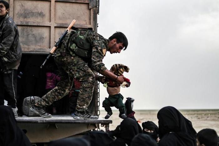US-backed Syrian Democratic Forces help civilians at a screening area for those who are evacuated from the Islamic State group's embattled holdout of Baghouz, during an operation to expel IS jihadists from the area on February 26, 2019