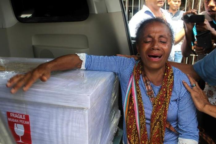Petronela Koa cries next to the coffin containing her niece, Adelina Sau, an Indonesian domestic helper who died in Malaysia after allegedly being abused by her employer