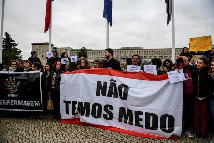 Striking Portuguese nurses hold a banner that reads "We are not afraid" as they demonstrate outside the Santa Maria central hospital in Lisbon