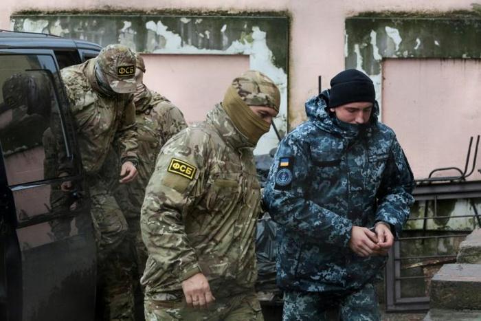 A Russian FSB security service officer escorts a detained Ukrainian sailor in Crimea in November -- a total of 24 sailors are still being held by Russia along with three naval vessels from Ukraine