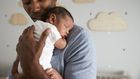 A daddy holding his new born baby.