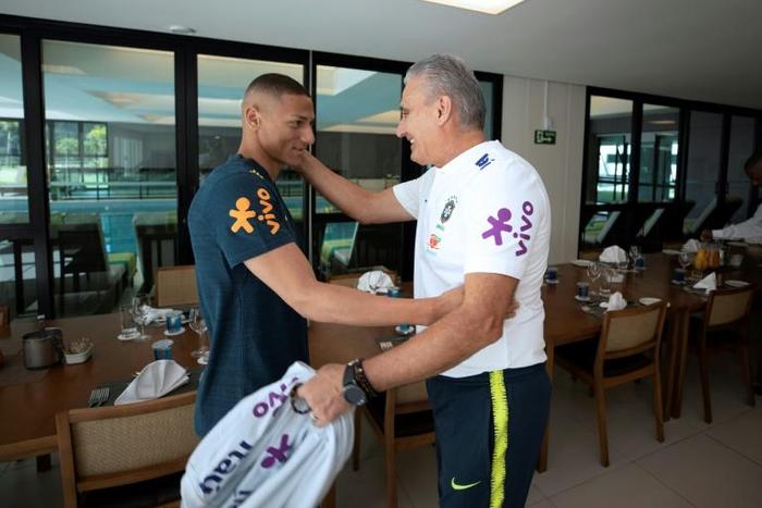 Happy to see you: the Brazilian Football Confederation released a photo showing coach Tite greeting Richarlison, the first player to turn up at a sparsely attended training camp